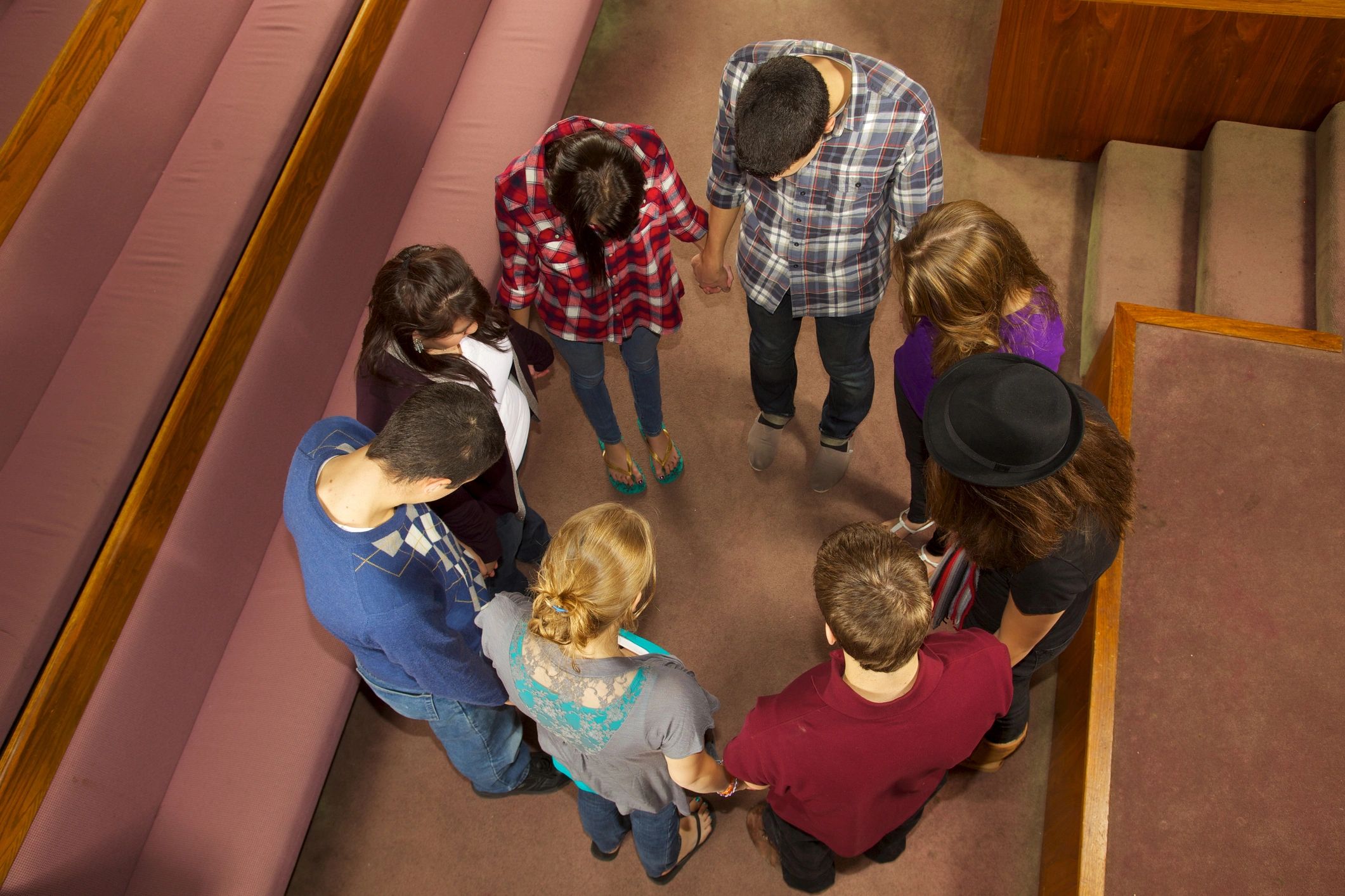 Young adults praying together in a church